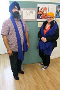 Chaz Singh (organiser of exhibition) and Melody Sale (artist) - Melody’s pencil sketch drawing of Bapu Surat Singh is in view; credit Hawk-Eye Photography